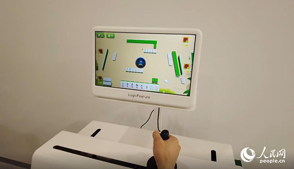 工作人員正在演示“運(yùn)動(dòng)-認(rèn)知康復(fù)機(jī)器人”。人民網(wǎng)記者 郝帥攝